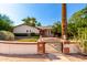 Charming home featuring a well-manicured front yard with a brick and stucco fence, gate, and mature landscaping at 5744 E Oak St, Scottsdale, AZ 85257