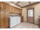 Well-equipped laundry room with tile floors, cabinets, and door to outside at 5744 E Oak St, Scottsdale, AZ 85257