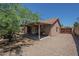 Exterior view of a home with an inviting covered patio and spacious gravel backyard, offering a serene outdoor living space at 5911 E Evergreen St, Mesa, AZ 85205