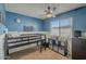 Bedroom with a bunkbed, stylish decor, a ceiling fan and bright blue painted walls at 5911 E Evergreen St, Mesa, AZ 85205