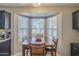 Cozy dining area with a wooden table set in front of a bright bay window for natural light at 5911 E Evergreen St, Mesa, AZ 85205