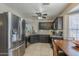 Functional kitchen featuring dark wood cabinets, stainless steel appliances and tile flooring at 5911 E Evergreen St, Mesa, AZ 85205