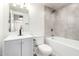 Well-lit bathroom features a shower-tub combo with tile surround, modern vanity, and neutral finishes at 6140 W Berkeley Rd, Phoenix, AZ 85035
