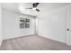Bright bedroom boasts a ceiling fan, plush carpet, and natural light from the window at 6140 W Berkeley Rd, Phoenix, AZ 85035