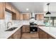 Modern kitchen with stainless steel appliances, light countertops, shaker cabinetry, and backyard views of the pool at 6140 W Berkeley Rd, Phoenix, AZ 85035
