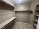 Walk-in closet featuring tile flooring, multiple shelves, and metal clothing rods at 6460 S Springs Pl, Chandler, AZ 85249