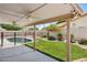 Covered outdoor patio with ceiling fans offers a relaxing view of the manicured backyard and pool at 6645 E Preston St, Mesa, AZ 85215
