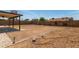 A flat backyard with a patio and framed area, surrounded by a block wall at 733 E Halifax St, Mesa, AZ 85203