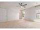 Spacious bedroom with a ceiling fan, neutral carpet, and bright window at 733 E Halifax St, Mesa, AZ 85203
