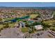 Aerial view showcasing the community clubhouse, pool, golf course, and tennis courts against a backdrop of city and mountains at 7531 W Kimberly Way, Glendale, AZ 85308