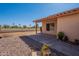Charming covered back patio featuring stone landscaping and a view of a green common area at 7531 W Kimberly Way, Glendale, AZ 85308