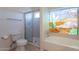 Bright bathroom featuring a separate tub with stained glass window, and a glass door walk-in shower at 7531 W Kimberly Way, Glendale, AZ 85308