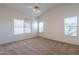 Spacious bedroom with neutral carpet, vaulted ceiling with ceiling fan and natural light from three windows at 7531 W Kimberly Way, Glendale, AZ 85308