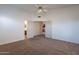 Spacious carpeted bedroom with ceiling fan and a view into another room through double doors at 7531 W Kimberly Way, Glendale, AZ 85308