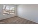 Empty carpeted bedroom with a bright window view and neutral white walls at 7531 W Kimberly Way, Glendale, AZ 85308