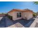 Side view of house featuring desert landscaping, and red tiled roof with tan paint at 7531 W Kimberly Way, Glendale, AZ 85308