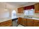 Cozy kitchen area with stainless dishwasher, wood cabinets, tile floors, and great light at 7531 W Kimberly Way, Glendale, AZ 85308