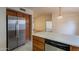 The kitchen features a breakfast bar, stainless fridge, tile floors, and neutral countertops at 7531 W Kimberly Way, Glendale, AZ 85308