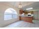 Eat-in kitchen with wood cabinets, tile floor, breakfast bar, and a lovely arch window at 7531 W Kimberly Way, Glendale, AZ 85308