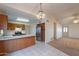Open kitchen with breakfast bar, stainless fridge, tile floors, and neutral color palette at 7531 W Kimberly Way, Glendale, AZ 85308