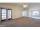 Spacious living room featuring ceiling fan, carpet flooring and glass doors at 7531 W Kimberly Way, Glendale, AZ 85308