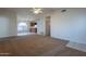 Spacious living room featuring carpet flooring, ceiling fan, and view into kitchen at 7531 W Kimberly Way, Glendale, AZ 85308
