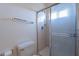 Bright bathroom featuring a walk-in shower with a glass door, toilet and towel rack at 7531 W Kimberly Way, Glendale, AZ 85308