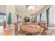 Cozy dining area with a round wooden table, decorative lighting, and a view into the living room at 8540 E Mcdowell Rd # 116, Mesa, AZ 85207