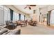 Spacious living room featuring high ceilings, a ceiling fan, and large windows with plantation shutters at 8540 E Mcdowell Rd # 116, Mesa, AZ 85207