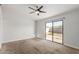 Spacious bedroom with neutral carpet, a ceiling fan, and sliding glass doors leading to the backyard at 9009 W Butler Dr, Peoria, AZ 85345