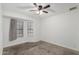 Bedroom with carpeted floor, ceiling fan, and two large windows at 9009 W Butler Dr, Peoria, AZ 85345