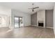 Bright living room featuring a cozy fireplace, sliding glass doors to the backyard, and tile floors at 9009 W Butler Dr, Peoria, AZ 85345