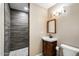 Well-lit bathroom with a stylish corner sink and tiled shower at 9214 N 54Th Ave, Glendale, AZ 85302