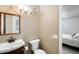 Cozy bathroom featuring a modern sink, toilet, and lighting fixtures at 9214 N 54Th Ave, Glendale, AZ 85302