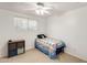 A cozy bedroom with a ceiling fan and a single bed featuring a colorful quilt at 9214 N 54Th Ave, Glendale, AZ 85302