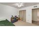Bedroom with ceiling fan, window, and small bed and blue storage boxes on shelving unit at 9214 N 54Th Ave, Glendale, AZ 85302