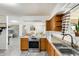 Bright kitchen featuring modern appliances, wood cabinets, and a view into the adjacent dining and living areas at 9214 N 54Th Ave, Glendale, AZ 85302