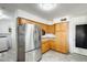A kitchen featuring stainless steel refrigerator, wood cabinets and gray wood-look tile flooring at 9214 N 54Th Ave, Glendale, AZ 85302