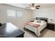 Comfortable main bedroom with a ceiling fan, side tables, and a dresser with a workspace at 9214 N 54Th Ave, Glendale, AZ 85302