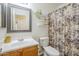 Charming bathroom with a floral shower curtain, floating shelves, and decorative mirror at 941 E Desert Moon Trl, San Tan Valley, AZ 85143