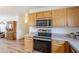 Close-up of the kitchen area highlighting modern appliances and wooden cabinets at 941 E Desert Moon Trl, San Tan Valley, AZ 85143