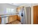 Bright kitchen showcasing a stainless steel refrigerator and wooden cabinets at 941 E Desert Moon Trl, San Tan Valley, AZ 85143