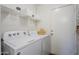 Bright laundry room with a white washer and dryer, white shelving, and a door to the outside at 941 E Desert Moon Trl, San Tan Valley, AZ 85143
