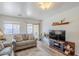 Well-lit living room featuring a comfortable sofa, large windows, and tasteful decorations at 941 E Desert Moon Trl, San Tan Valley, AZ 85143
