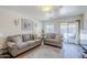 Cozy living room with comfortable sofas, neutral tones, and sliding glass door to outside at 941 E Desert Moon Trl, San Tan Valley, AZ 85143