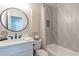 Bright bathroom featuring a round mirror, modern vanity, and stylish textured shower tiles at 1005 N Granite Reef Rd, Scottsdale, AZ 85257