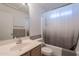 Modest bathroom featuring single sink, ceramic tile accenting, toilet and a shower with curtain in neutral decor at 10305 E Dragoon Ave, Mesa, AZ 85208
