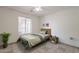 Minimalist bedroom with a light color scheme, simple wooden bed frame, decorative side table, and a leafy green plant at 10305 E Dragoon Ave, Mesa, AZ 85208