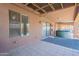 Covered patio with tile flooring, a hot tub, and access to the backyard with a view of the neighbor's yard at 10305 E Dragoon Ave, Mesa, AZ 85208