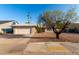 Charming single-story home with a two car garage, xeriscape front yard, and mature desert landscaping at 1055 E Ingram St, Mesa, AZ 85203
